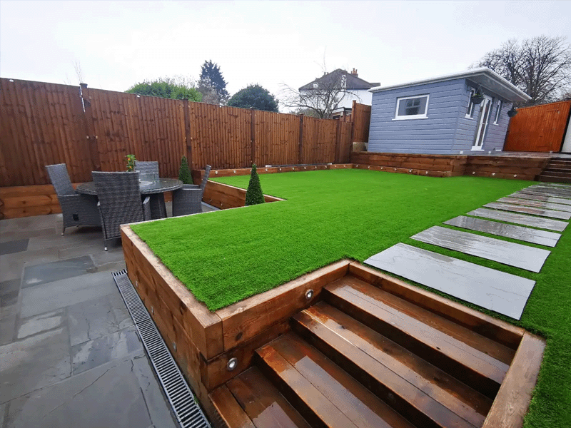 Garden view showing the wooden septs up to the artificial grass and garden room at the back