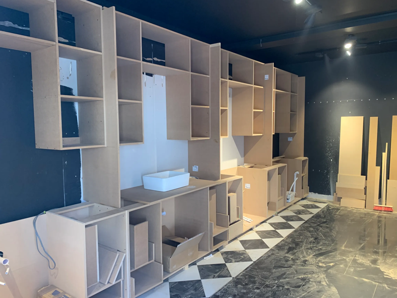 Unfinished MDF wall shelving units and base cupboards.