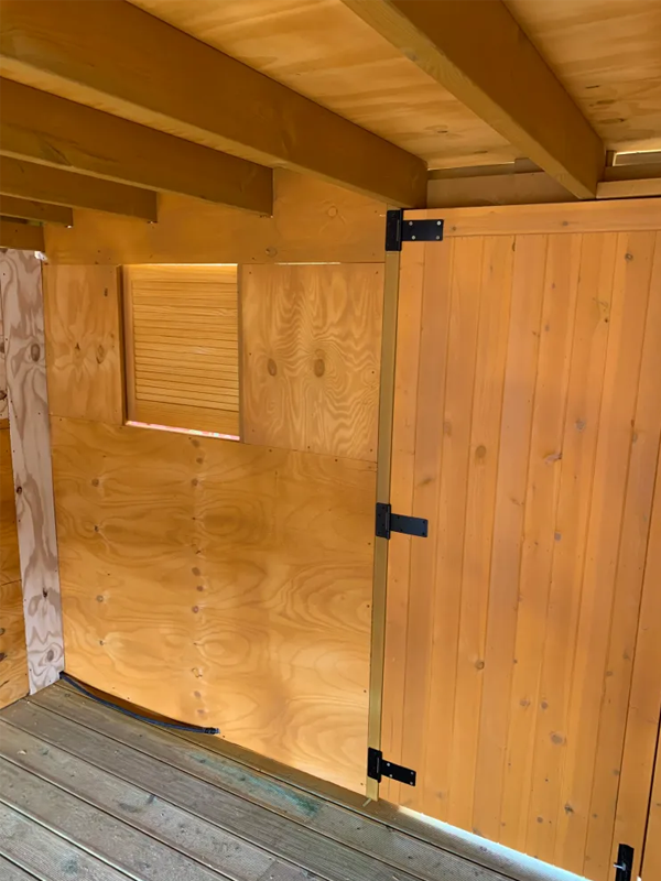The internal vew of a pergola with focus on the timber celling beams and door