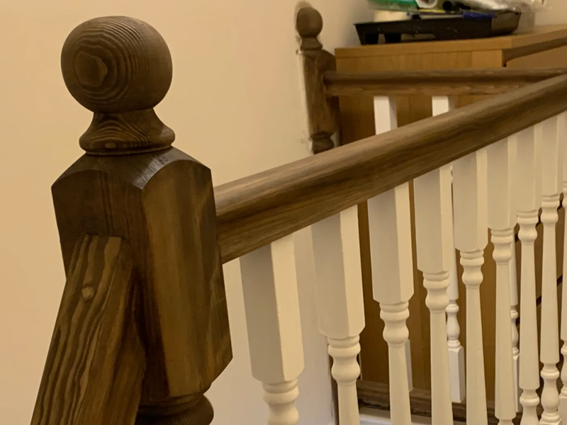 front view 1 st floor landing area brown stained handrail and posts, spindles in white colour  
