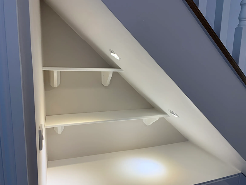 front view shelves under the stairs with spot light incorporated in the stairs 