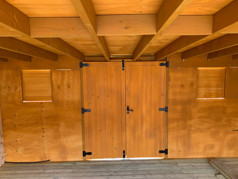 Inside treated timer pergola with interior timber decking and stable doors