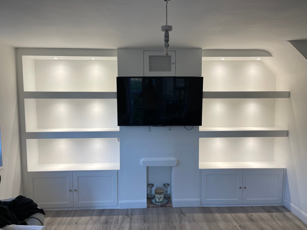 Room alcove with fitted shelves and cupboard