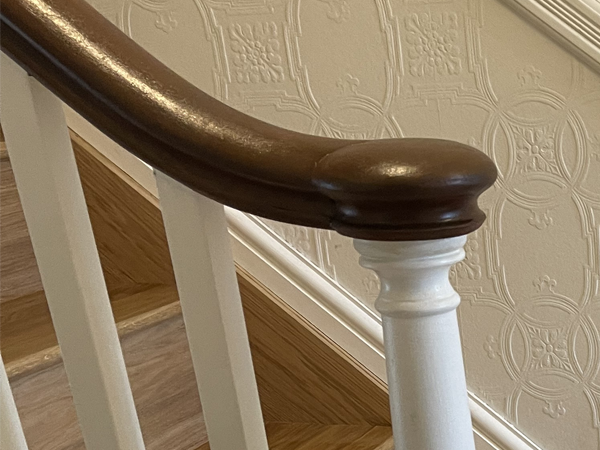 Close up of stained handrail and white painted spindles